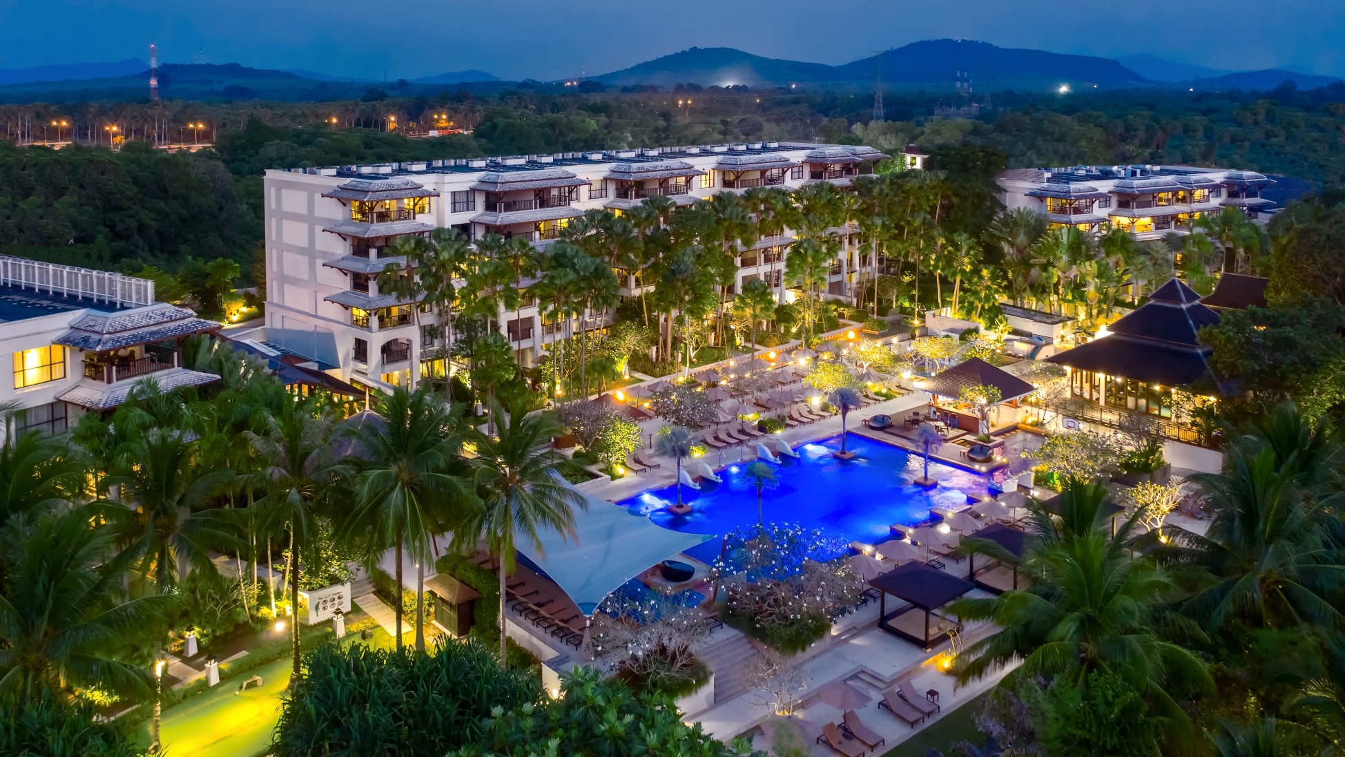 Aerial of exterior and pool deck at dusk of Marriott's Mai Khao Resort timeshare in Phuket, Thailand